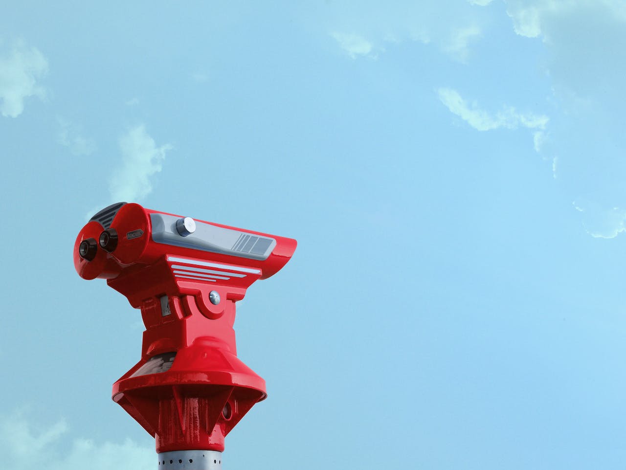 Ein rotes Fernrohr und blauer Himmel.